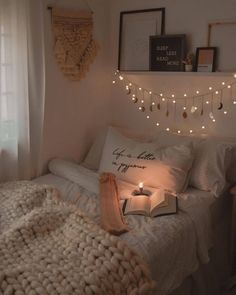 a bedroom with lights strung from the ceiling and a bed in front of a window