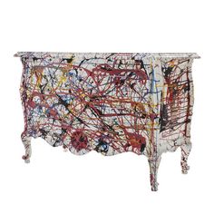 an artisticly painted cabinet with drawers and legs, on display in front of a white background