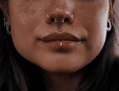 a woman with piercings on her nose and nose ring in front of her face