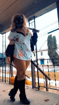 a woman dressed up as a zombie walking down the street with her hands in her pockets