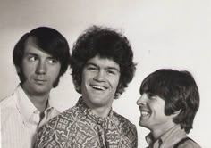 three men standing next to each other smiling