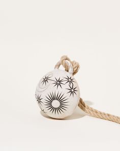 a white and black ornament hanging from a rope