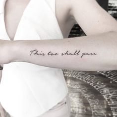 this too shall pass tattoo on the left forearm and arm, with words written in cursive font