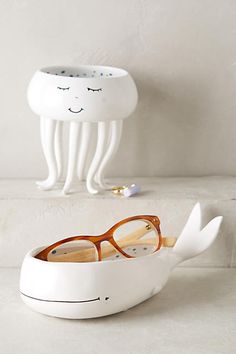 a pair of glasses sitting on top of a white table next to a jellyfish