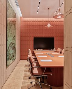 an orange conference table in the middle of a meeting room with chairs and a television mounted to the wall