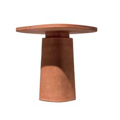 a brown vase sitting on top of a wooden table