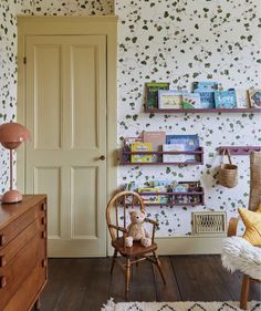 a child's room with wallpaper and wooden furniture