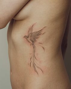 a woman's stomach with a bird tattoo on it