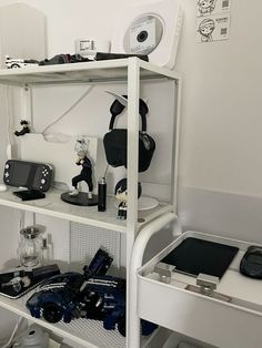 there is a shelf with many items on it in the room that has white walls