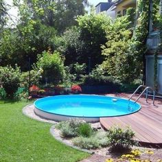 an above ground pool surrounded by lush green grass