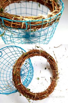 two blue wire baskets filled with twigs and grass