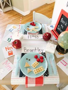 a table topped with plates of food next to an apple and other items on top of it