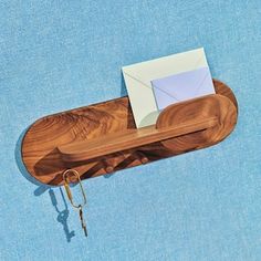 an overhead view of a wooden desk with a key and envelope on it, against a blue background