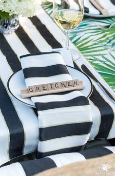 a place setting with black and white striped napkins, silverware and wine glasses