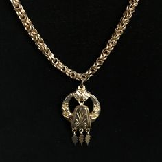 Ce collier chaîne est en métal doré laminé vieilli. Il se compose de nombreux maillons de fine chaîne pliée à la main, reliés par d'épais anneaux en or. Ce style de chaîne est appelé byzantin et est léger car il est entièrement ajouré. Le pendentif léger de style étrusque mesure 1,5 pouce et est ajouré. La pièce centrale est suspendue à un pivot au-dessus du cerceau de travail ouvert avec trois petites feuilles plates suspendues qui pendent avec le mouvement. La longueur du collier est de 18 pou Thick Gold Rings, Costume Jewelry Makers, Thick Gold Ring, Byzantine Necklace, Vintage Chain, Victorian Jewelry, Jewelry Maker, Metal Necklaces, Selling Jewelry