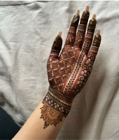 a woman's hand is decorated with hennap and intricate designs on it