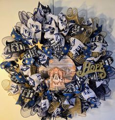 a wreath made out of blue and white ribbons with an image of jesus on it