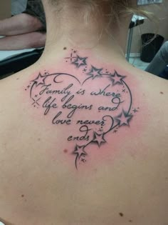 the back of a woman's neck with a heart and stars tattoo