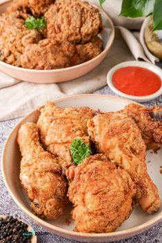 fried chicken on a plate with dipping sauces and seasoning next to it in bowls