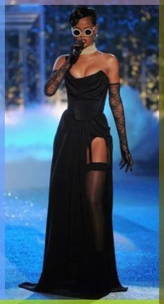 a woman in a black dress on the runway