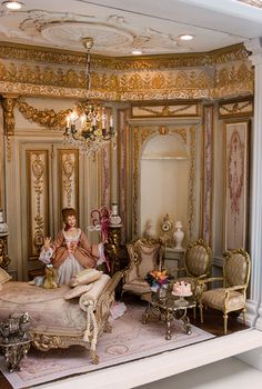 a woman sitting on top of a bed in a room with gold walls and furniture