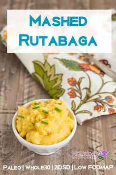 mashed rutabaga in a white bowl next to a napkin on a wooden table