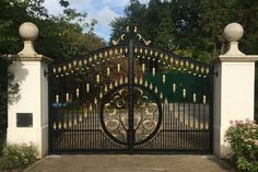 an iron gate with gold bells on it