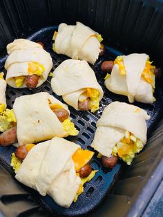 there are eight wrapped hotdogs in the air fryer with eggs and cheese