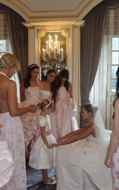 a group of women standing next to each other in front of a bride and groom