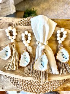 five seashells and tassels on a wooden tray