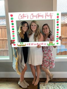 three women standing in front of a christmas party sign holding up a lifesifte