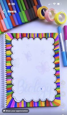 an open notebook with markers and pens on it