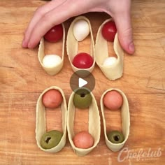 an image of some food being made on a wooden table with fingers pointing at it