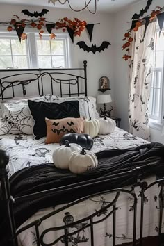 a bedroom decorated for halloween with black and white decor