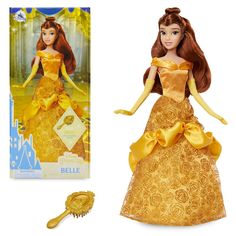 the doll is wearing a golden dress and has a brush in it's hand