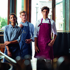 three people standing next to each other in front of a window with an apron on