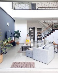 a living room filled with furniture next to a stair case