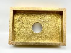 a gold square shaped tray with a hole in the middle