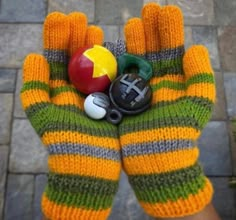 a person's hand with an orange and green striped mitt holding various items