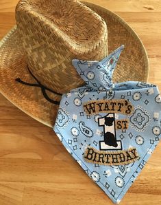 a cowboy hat and bandana on top of a wooden floor next to a birthday tie