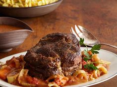 a piece of steak with pasta and vegetables on a plate