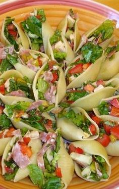 a plate filled with pasta and vegetables on top of a wooden table