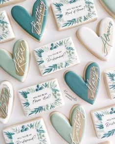 cookies decorated with blue and white icing are arranged in the shape of hearts