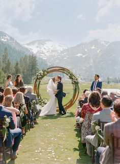 a bride and groom are standing under an arch at their wedding ceremony in the mountains