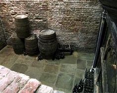 several barrels are stacked on the floor next to each other in front of a brick wall