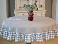 a vase filled with flowers sitting on top of a table next to a white dresser