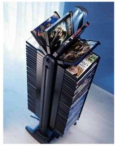 a stack of dvd's sitting on top of a black cart next to a window