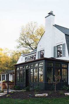 a large white house sitting on top of a lush green field