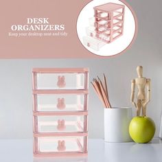 the desk organizer is pink and has three drawers with bunny ears on them, along with an apple