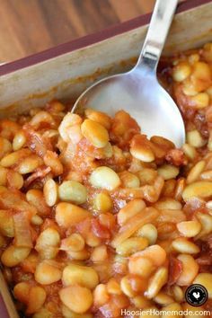 a spoon in a dish filled with beans